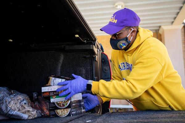 Michael Evans, pastor of Bethlehem Baptist Church in Mansfield, loads food into the back of the truck of a woman who lost her job during the COVID-19 shutdown. Texas Baptist Men has helped triple the capacity of Bethlehem's food distribution.