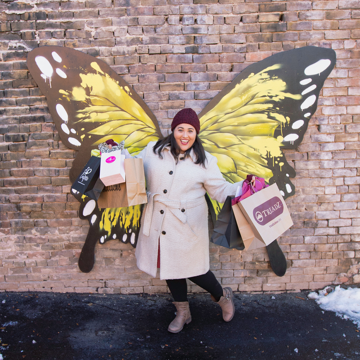 Woman posing in front of set of Glenwood Wings while enjoying historic downtown Glenwood Springs. 