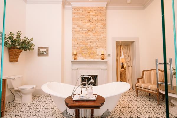 Relax in the Sarah Reed Suite's luxurious oversized clawfoot bathtub by the cozy fireplace. This suite consists of 2 of the 4 original rooms in the historic hotel.