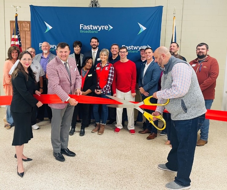 Officials from the City of Leesville, La., joined Fastwyre Broadband representatives in a November 13, 2023, ribbon-cutting ceremony that marked the official launch of Fastwyre’s high-speed, affordable fiber-optic network for area residents and businesses in Leesville. At the Leesville Municipal Golf Course Reception Hall, pictured cutting the ceremonial ribbon are, from left, Dr. Christina Lord, Board Chair of the Greater Vernon Chamber of Commerce; Leesville Mayor Rick Allen; and Cody Crader, Business Sales Executive for Fastwyre Broadband.