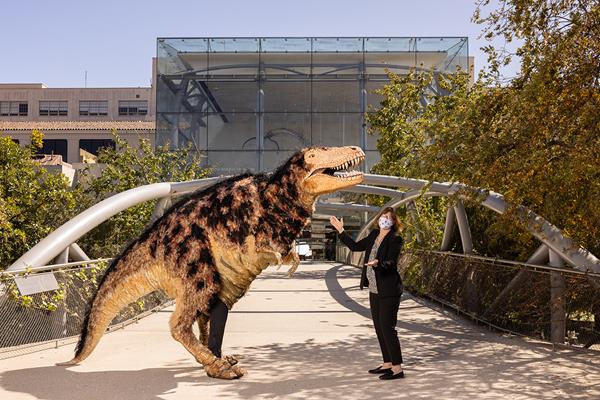 Dr. Lori Bettison-Varga, President and Director of the Natural History Museums of Los Angeles County (NHMLAC), and Hunter the T-Rex puppet welcome back visitors to the Natural History Museum of Los Angeles County (NHM). Exposition Park, Los Angeles, CA. April 1, 2021. Photography by Gina Cholick. 