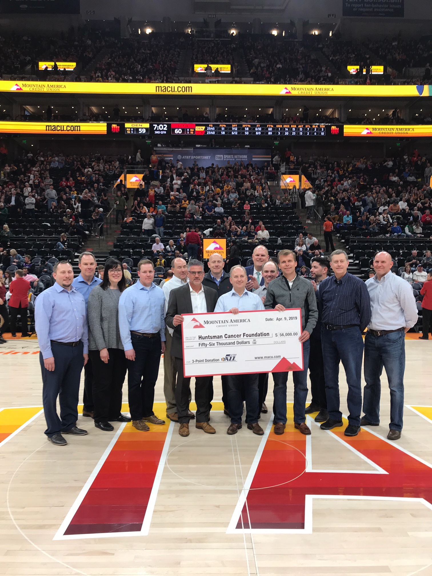 Mountain America senior leadership team presents a $56,000 check to David Huntsman, who represented Huntsman Cancer Foundation, at the Utah Jazz game on April 9, 2019.