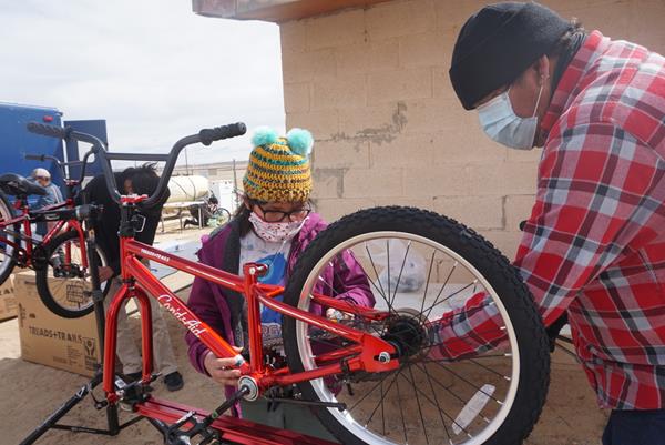 Can'd Aid volunteers help build bicycles for underserved youth.