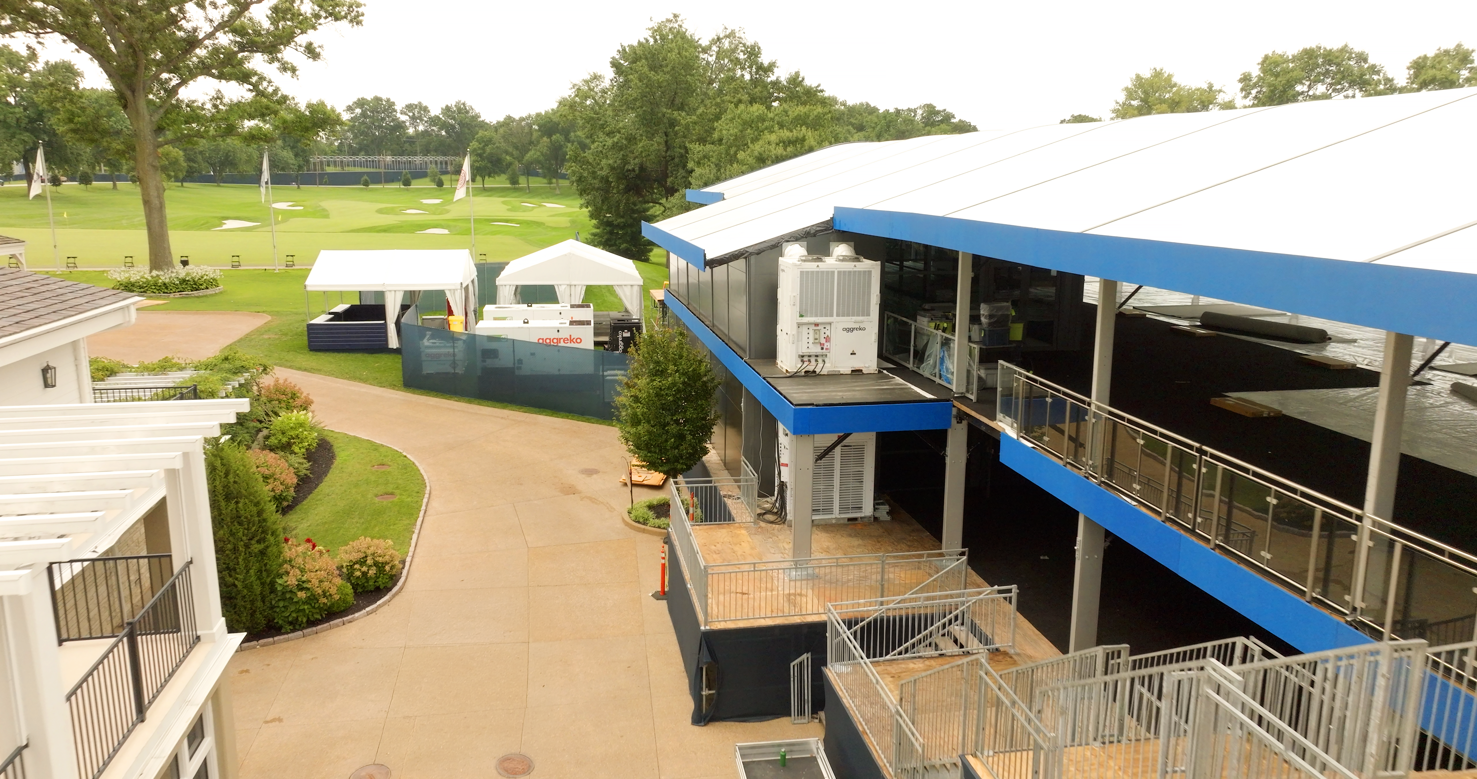 At a golf course, Aggreko-branded containers with energy and temperature control equipment are seen at hospitality areas