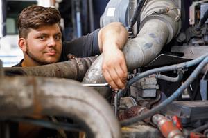 A Casella diesel technician pauses for a photo while he works on a truck.