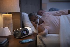 Woman Sleeping with Nasal Pillow with Device and Phone on Nightstand