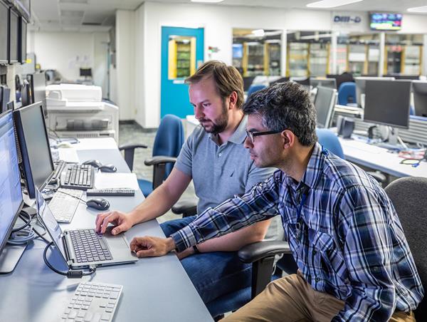GA researchers Andrey Lvovskiy (left) and Carlos Paz-Soldan (right) working at the DIII-D National Fusion Facility in San Diego have discovered a new mechanism for preventing potentially damaging phenomena known as “runaway electrons” in fusion reactors. Courtesy General Atomics