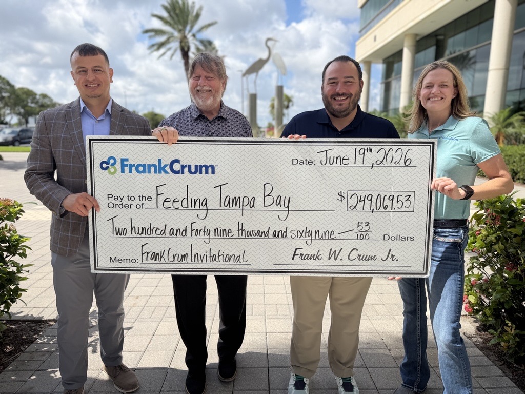 FrankCrum representatives present a ceremonial check to Feeding Tampa Bay outdoors in the company courtyard.