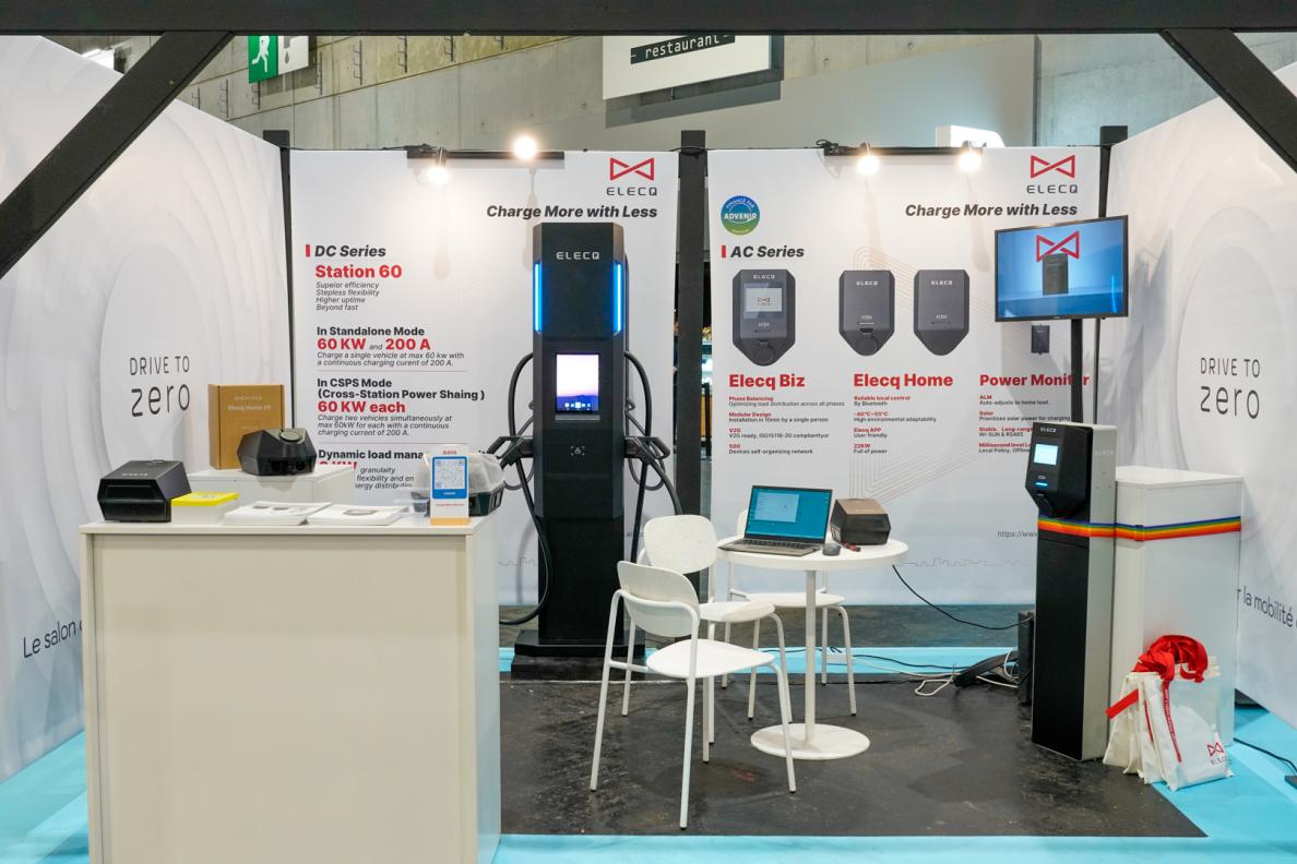 ELECQ exhibition booth at Drive to Zero 2025, showing various EV chargers, interactive displays, and brand signage with visitors walking around.