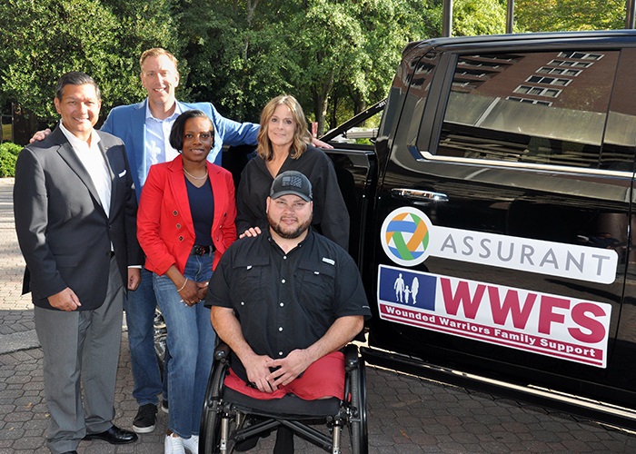 Assurant, through the Assurant Foundation, teamed with Wounded Warrior Family Support Tuesday to present combat-wounded veteran Sean Adams of Gainesville, Georgia, with a mobility-modified 2022 Chevrolet Silverado 2500 Truck. Pictured (from left to right) are Assurant's Alex Punsalan, Keith Demmings and Alecia Bailey, Kate McCauley of Wounded Warriors Family Support and Adams.