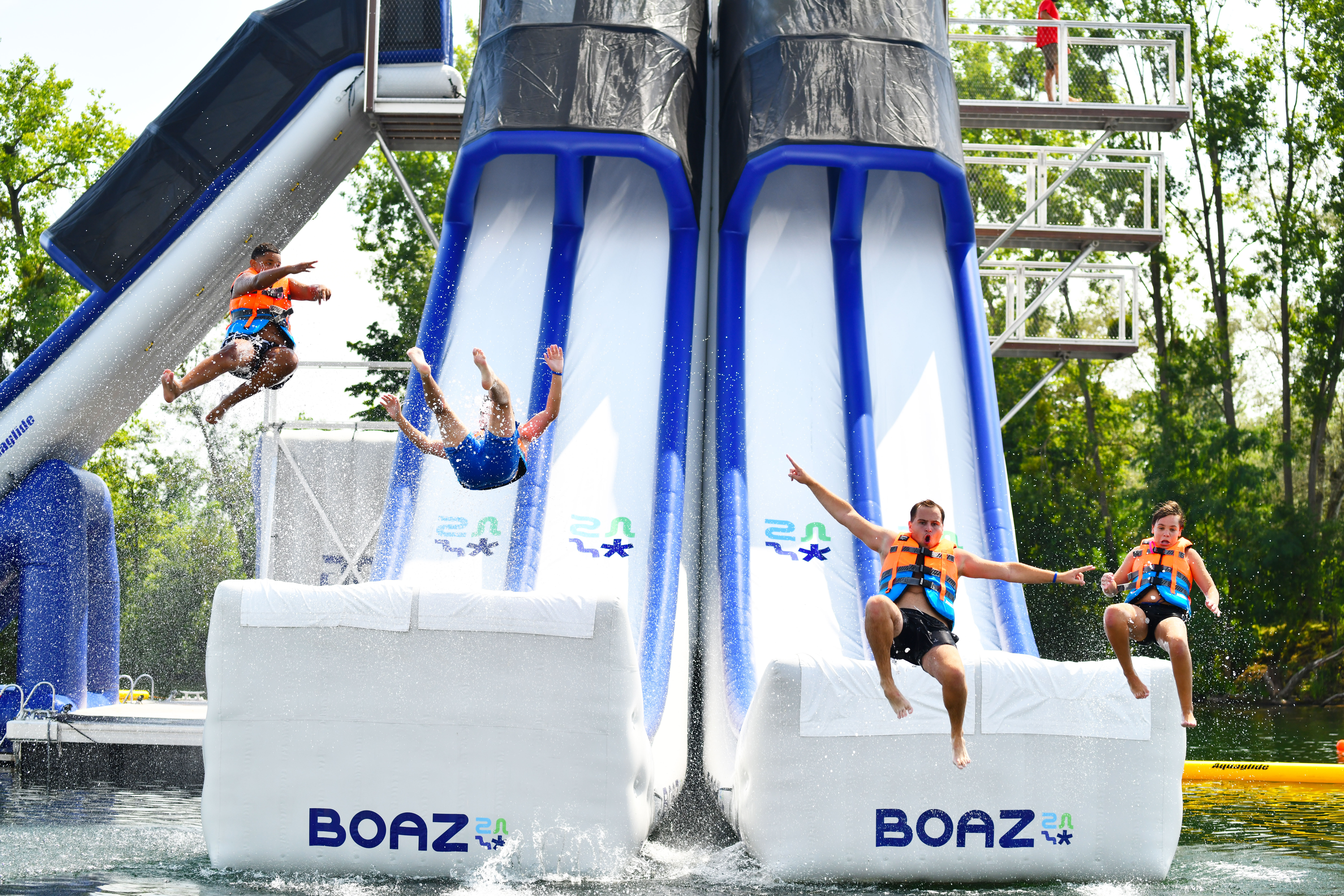 Guests sliding and jumping from the XTower floating attraction.