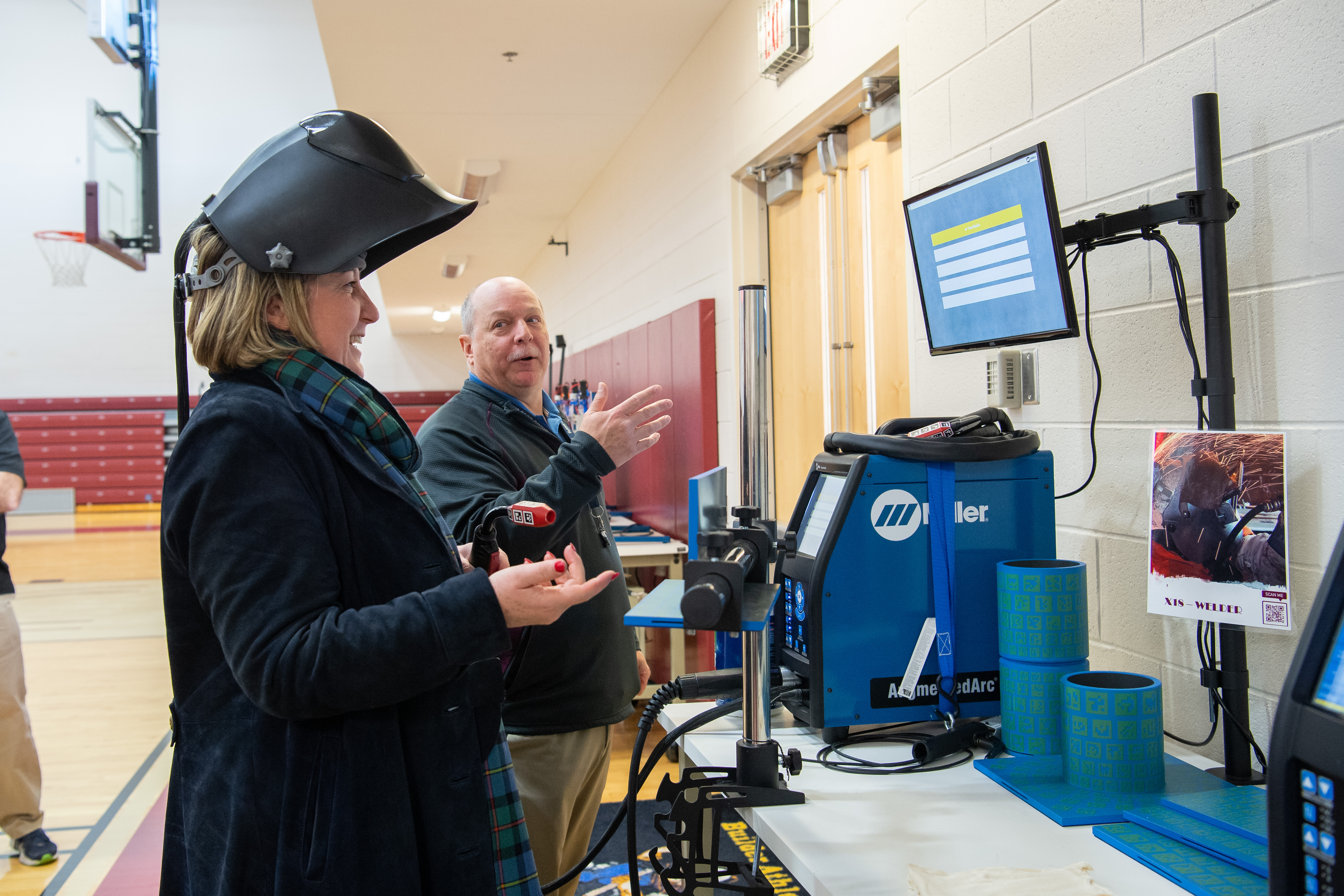 United Kingdom Minister of State (Indo-Pacific) Anne-Marie Trevelyan, left, experiences digital shipbuilding technology while visiting the Ray Bagley Innovation Lab on a tour of The Newport News Shipbuilding Apprentice School during a visit to shipbuilder and all-domain technologies provider HII on Monday, January 22, 2024. At right is Apprentice School instructor Jimmy Jessup (Photo by Ashley Cowan/HII).