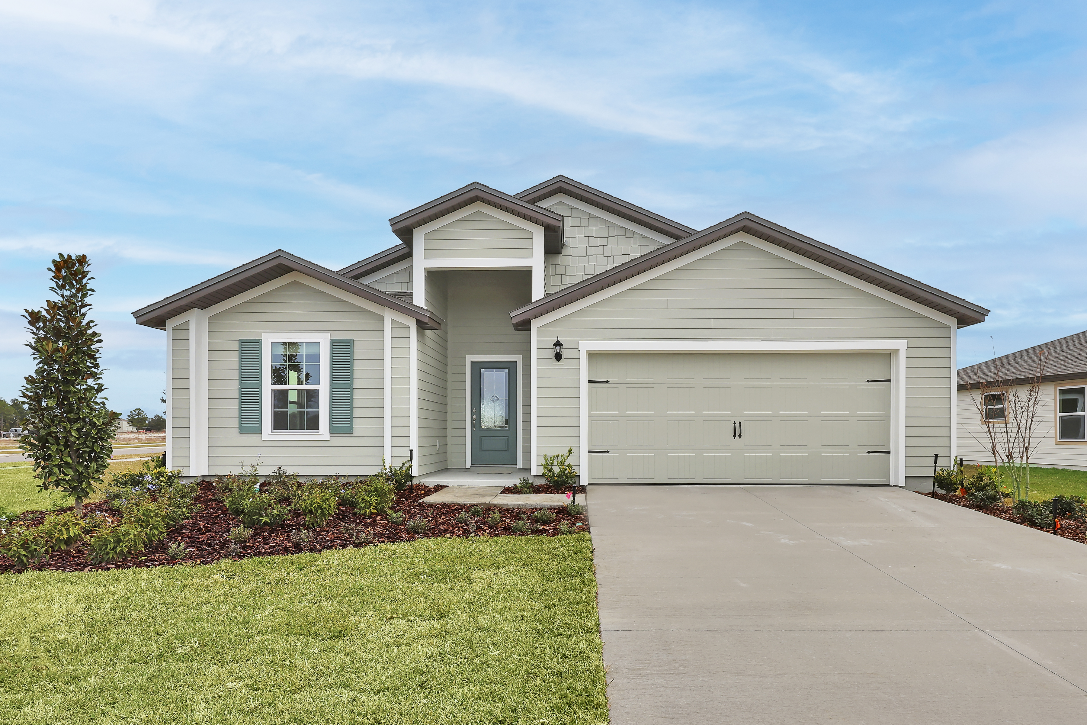 Photograph of the one-story Hillcrest plan by LGI Homes in gray and sage green siding with white trim.