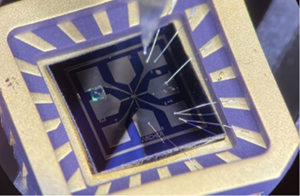 An Archer 4 x 4 mm single-chip quantum electronic device after installing and bonding into a commercial chip carrier. This completed device is compatible with measurement setups for electronic characterisation at cryogenic temperatures as well as ambient conditions at room temperature using Archer’s in-house lab capabilities as well as external facilities.