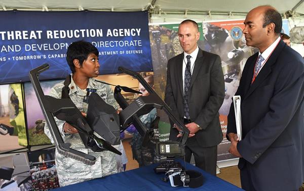 An Air Force officer currently assigned to DTRA’s Research and Development Directorate shows off a part of MACS-B and what this particular component looks like when it transforms from a tracked unmanned ground vehicle into a quadcopter UAS.