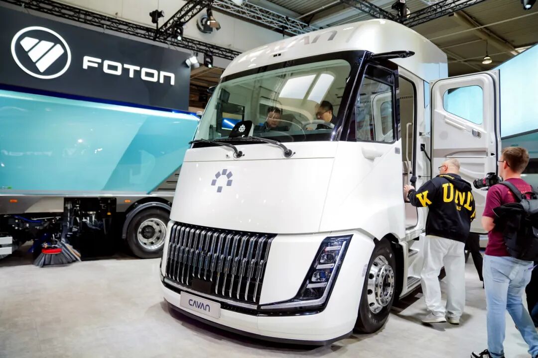 Visitors examine the CAVAN BEACON cab and interior at the BAIC FOTON exhibition stand.