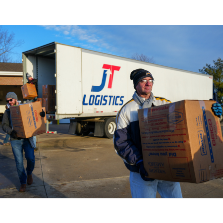 Volunteer crews unload veteran wreaths from JT Logistics truck for placement throughout Iowa cemeteries.