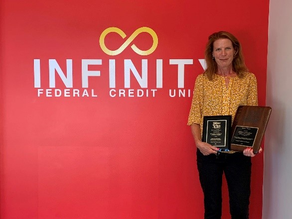 Elizabeth Hayes, Infinity Federal Credit Union (FCU) President and CEO, shown with the second-place Louise Herring Philosophy-in-Action Member Service Award and the first-place Dora Maxwell Social Responsibility Community Service Award.