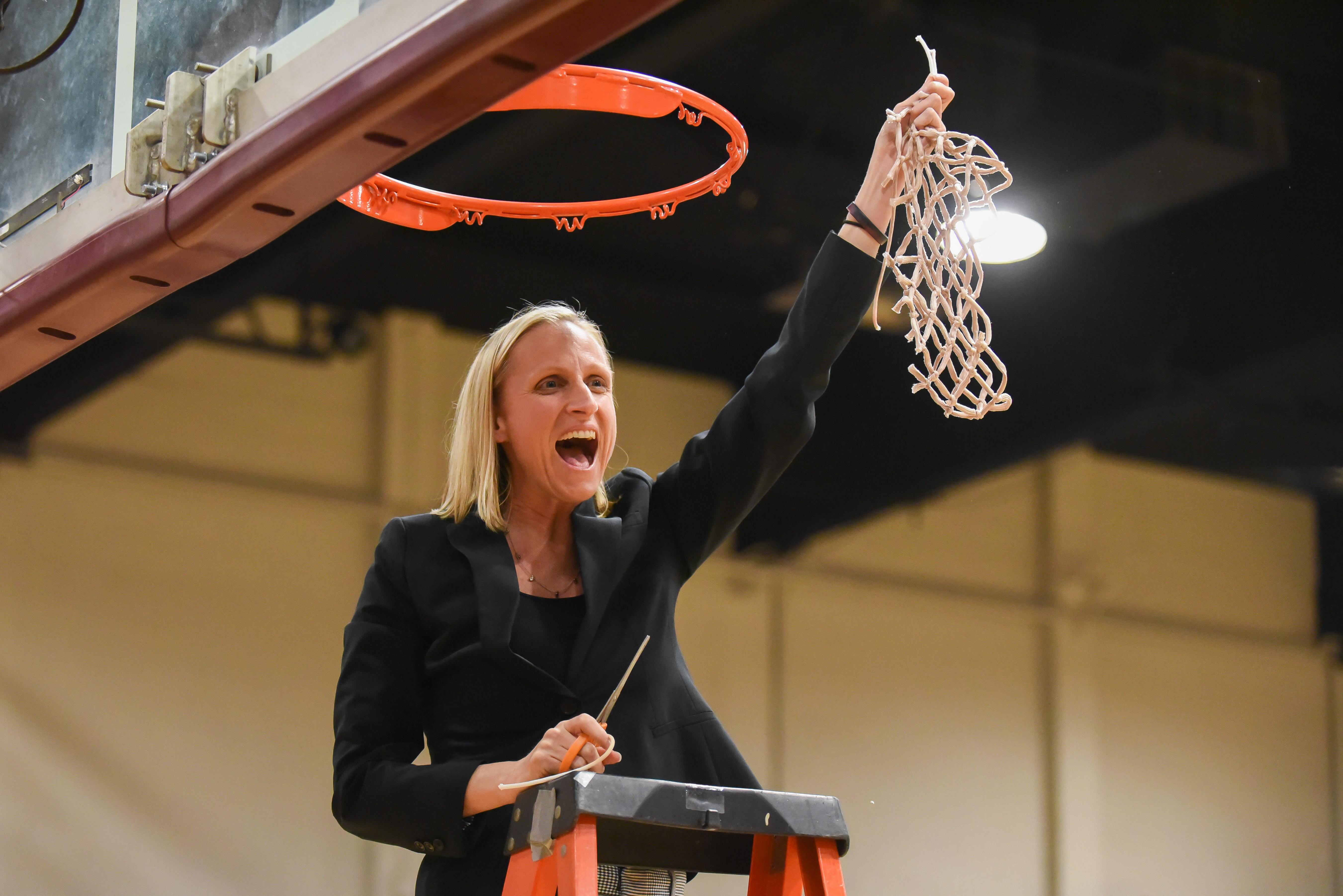 Kirsten Moore, head coach of the Westmont women's basketball team, cuts the nets following the Warriors fifth straight Golden State Athletic Conference Tournament Championship on March 7 in Murchison Gym.  