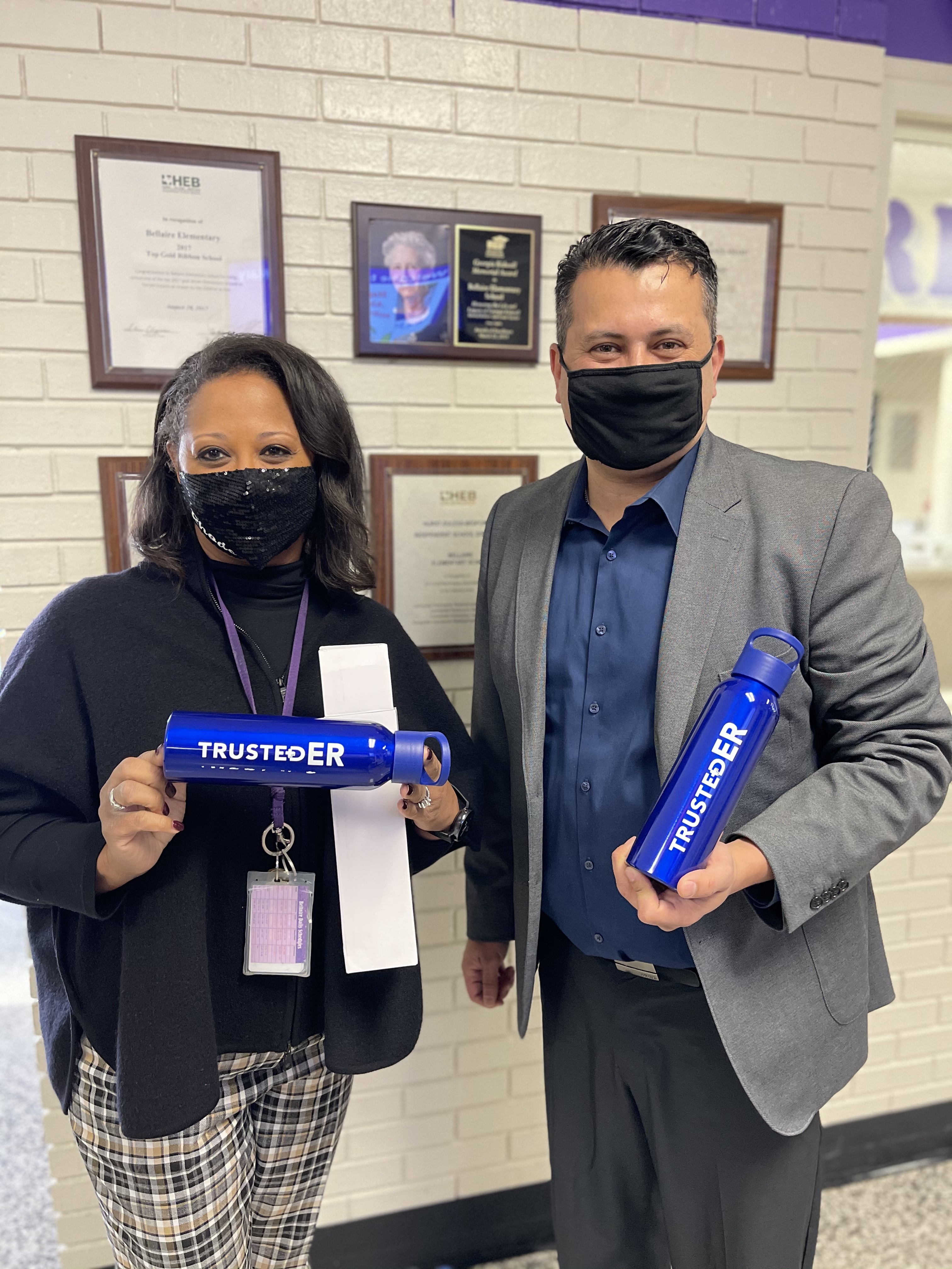 Trusted Medical co-founder and President, Harvey Castro, MD and Principal Katina Rhodes pose with the reusable water bottles donated by Trusted ER for students at Bellaire Elementary in Hurst, TX. The bottles are designed to keep students hydrated throughout the day as the school's water fountains are out-of-service due to COVID-19.