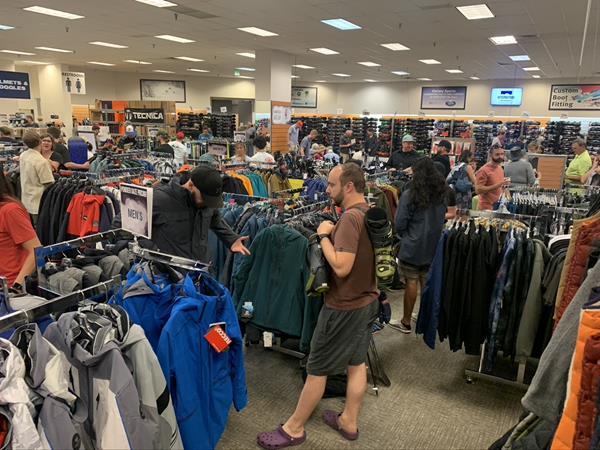 Interior of a Christy Sports store with many people trying on winter clothes and gear
