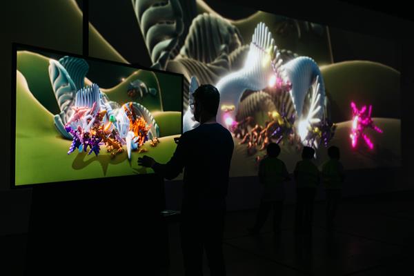 A visitor creates his own creature out of thin air and unleashes it in a digital terrarium in Wave Atlas, a new art instillation at The Tech Interactive in San Jose, CA by Marpi.