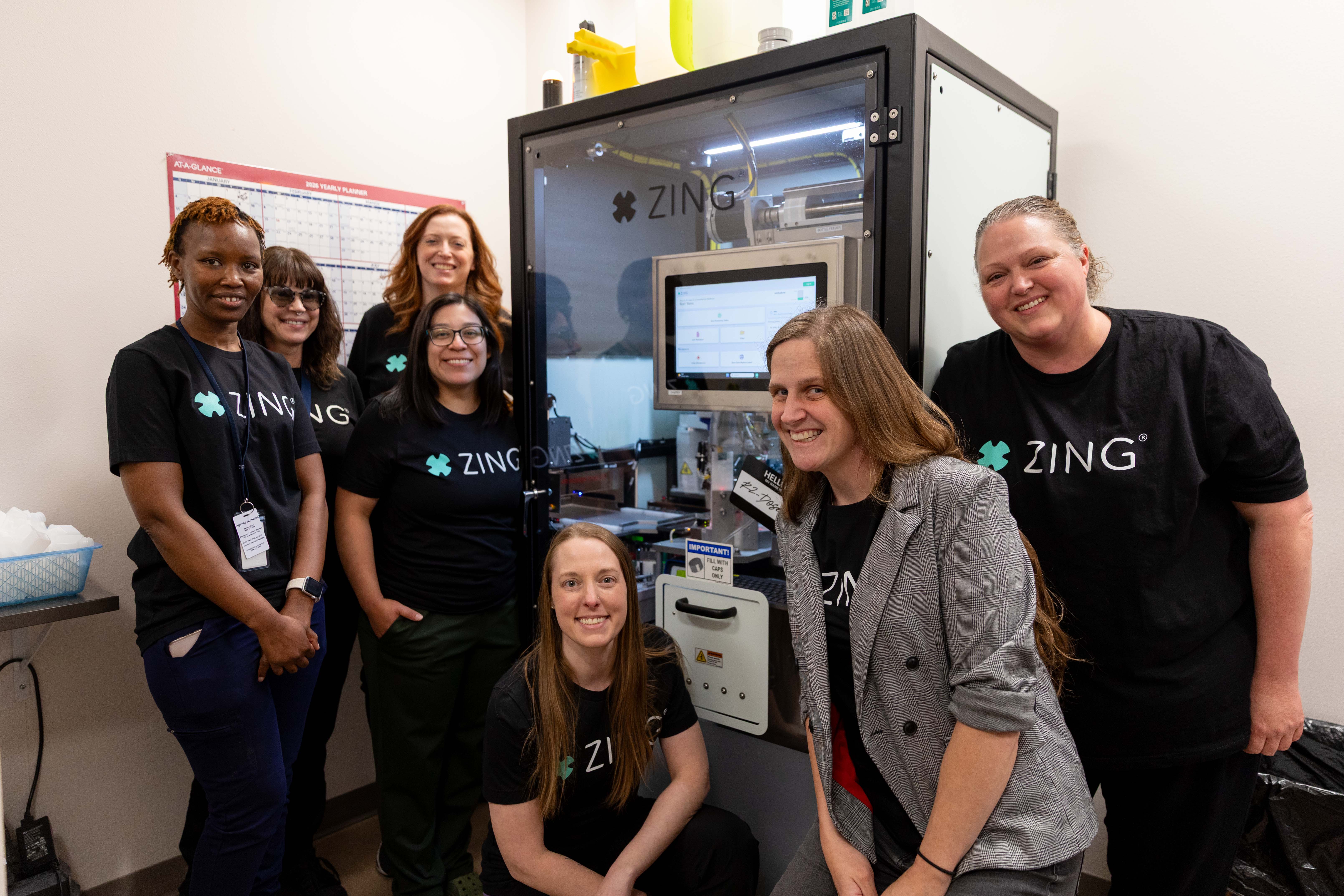 Comprehensive Healthcare staff pose with the ZING robotic methadone dosing system at the organization's Opioid Treatment Program clinic in Yakima.