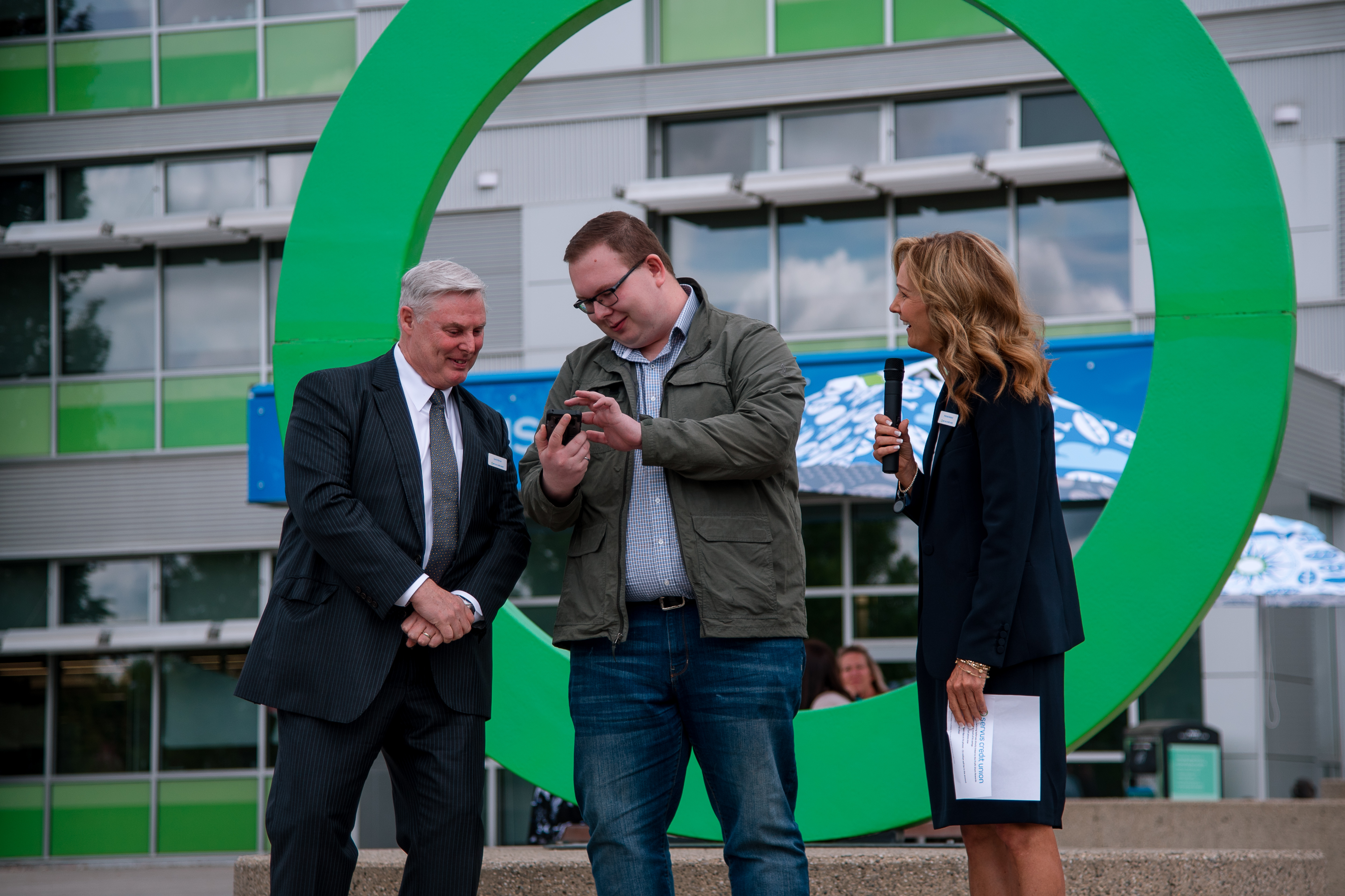 Andrew Buchner showing Garth Warner (Left) and Michelle Belland (Right) the million dollars that was deposited into his account