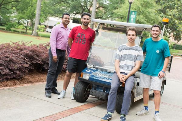 Dr. Hasitha Mahabaduge (left) with Georgia College physics students in 2017 and their solar-powered golf cart.
