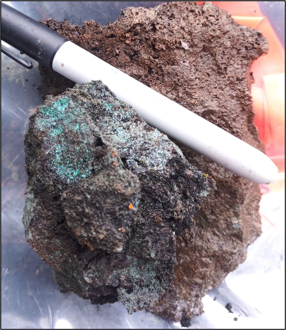 Mineralization at the Sibola Target, sample 997066 (<percent>1.19%</percent> copper). Altered volcanic rock exposed over 2 metres containing quartz-carbonate veining, iron staining, and malachite.