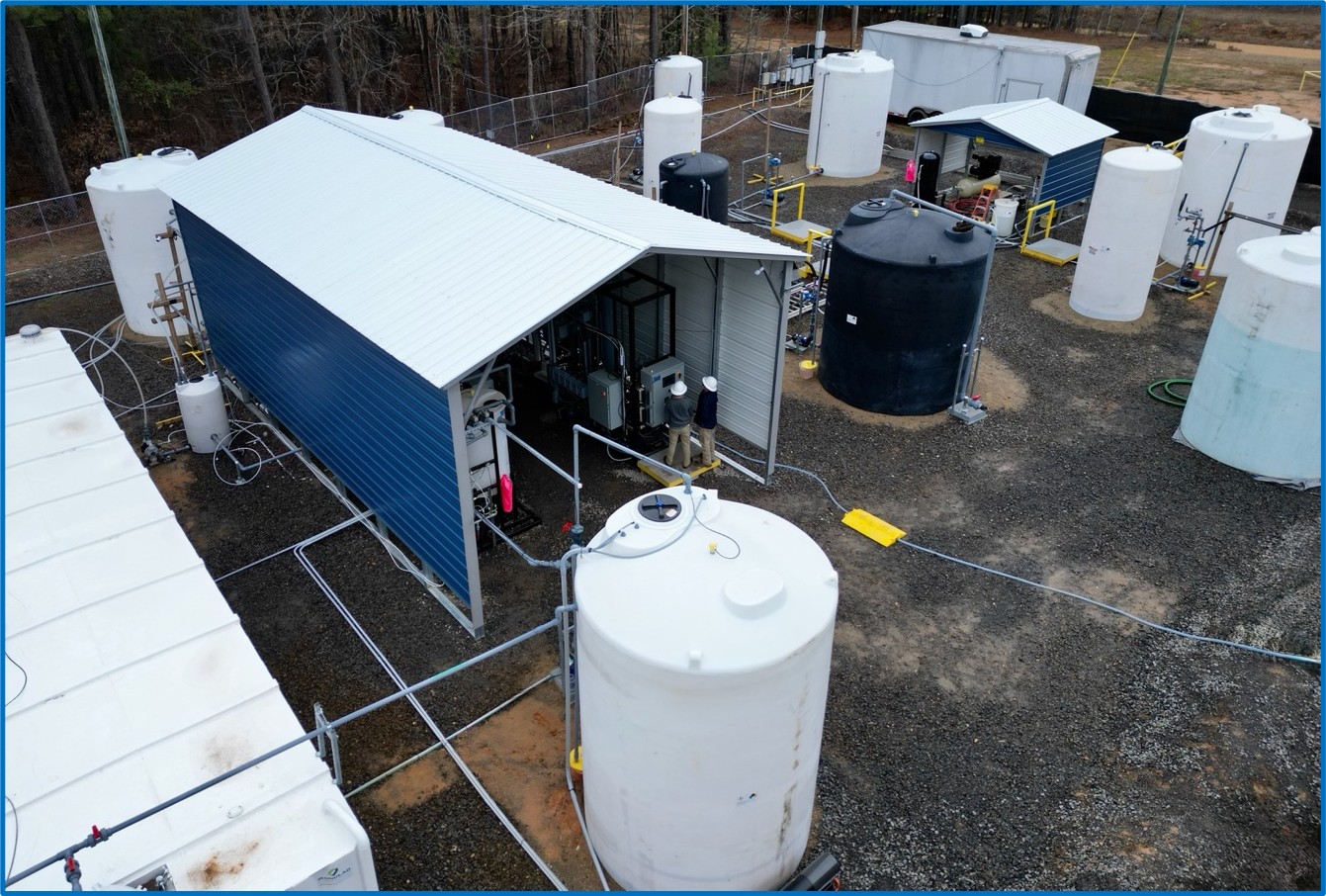 Standard Lithium operators checking performance of the DLE field pilot.  The larger blue and white enclosure houses the pre-treatment, filtration and DLE (LSS column) process steps.