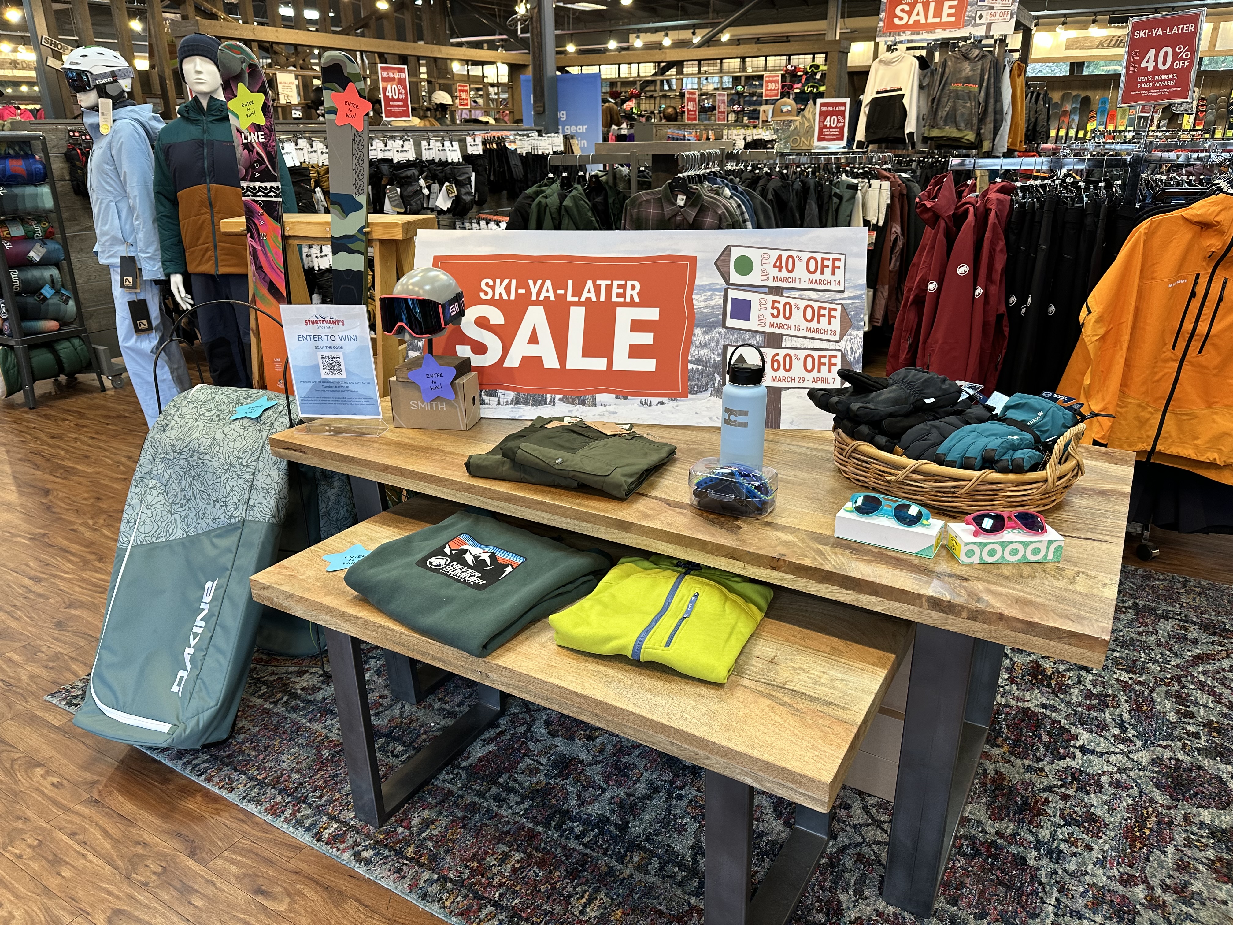 Image shows the inside of a Christy Sports store with clothing and items displayed for the Ski-Ya-Later Sale