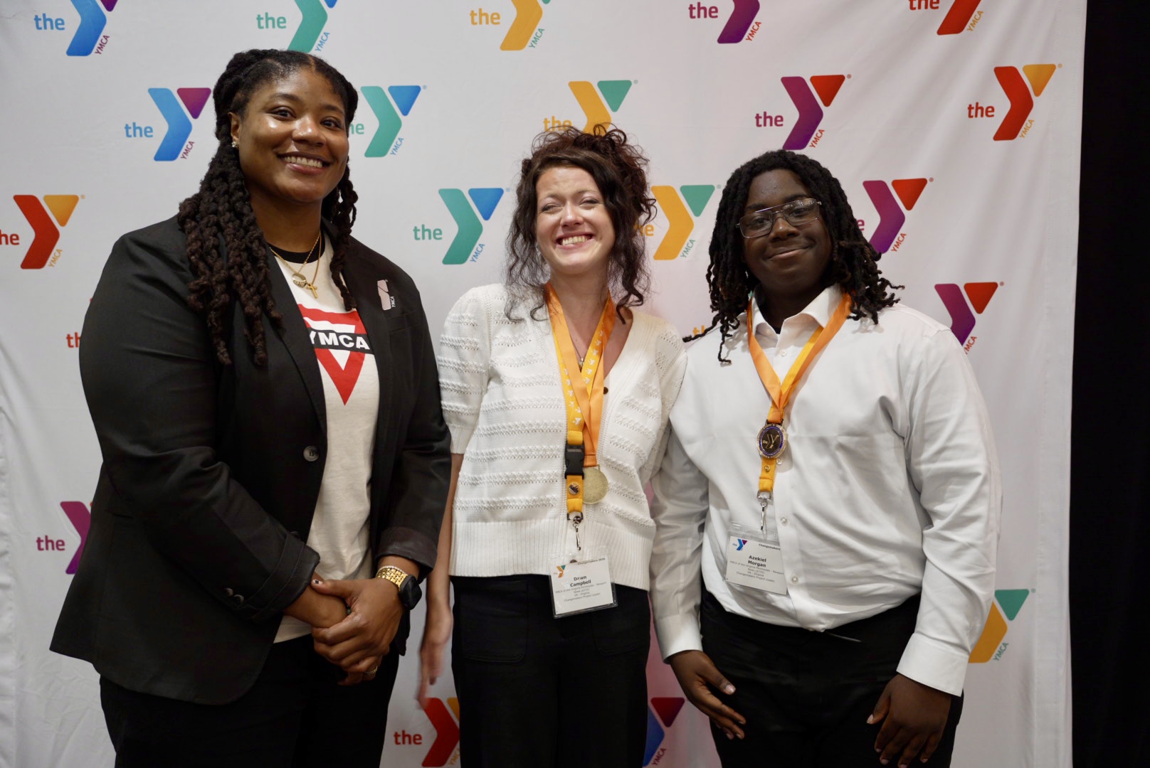 YMCA of the USA Director of Teen Strategy, E Mitchell, congratulates 2026 Changemakers Summit winners Dawn C. and Azekiel M. (YMCA of the Virginia Pen