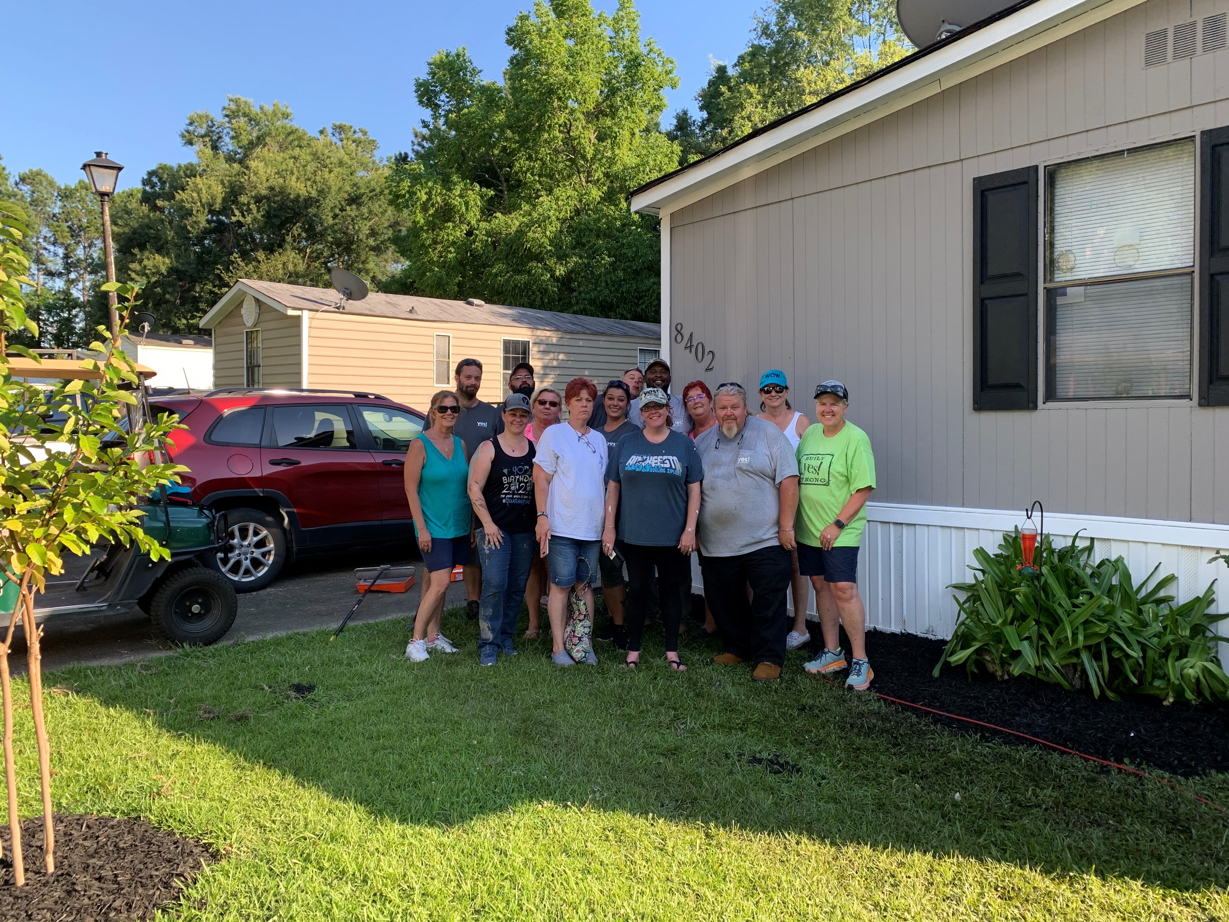 YES team members standing next to the renovated home