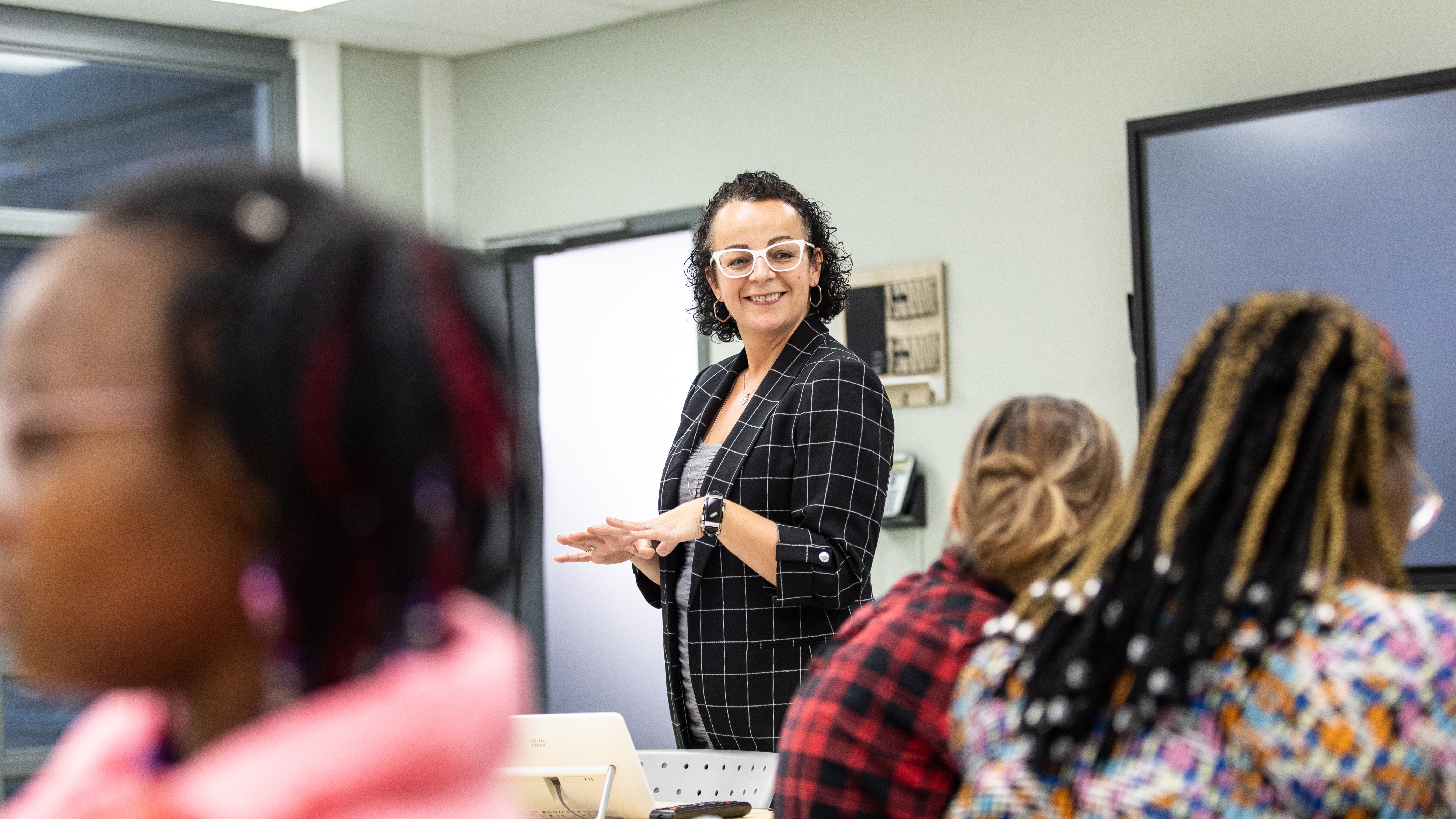 Une professeure souriante enseigne dans un cours d'éducation en services à l'enfance.