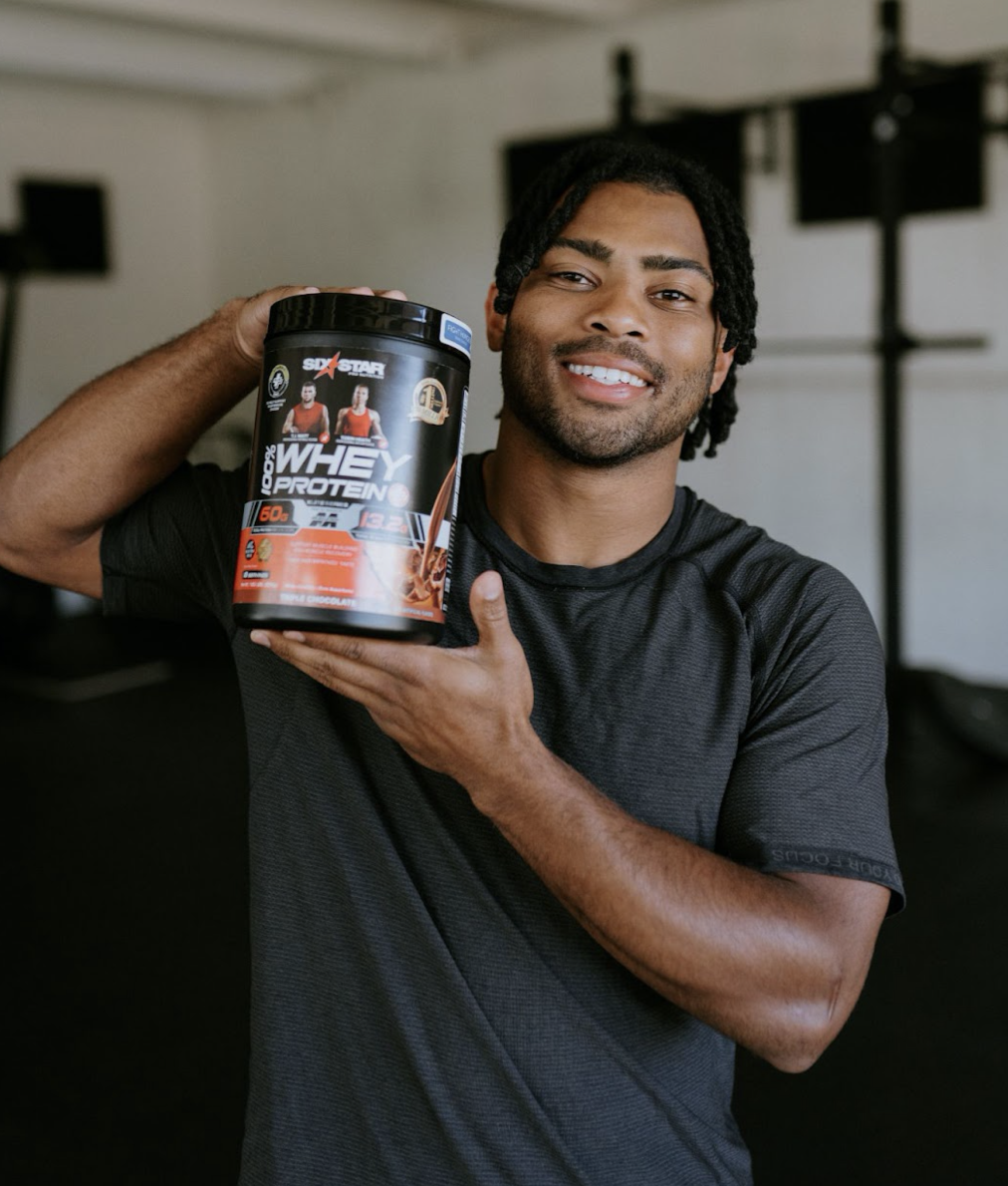 Darien Rencher poses with a bottle of Six Star Pro Nutrition® 100% Whey Protein Plus