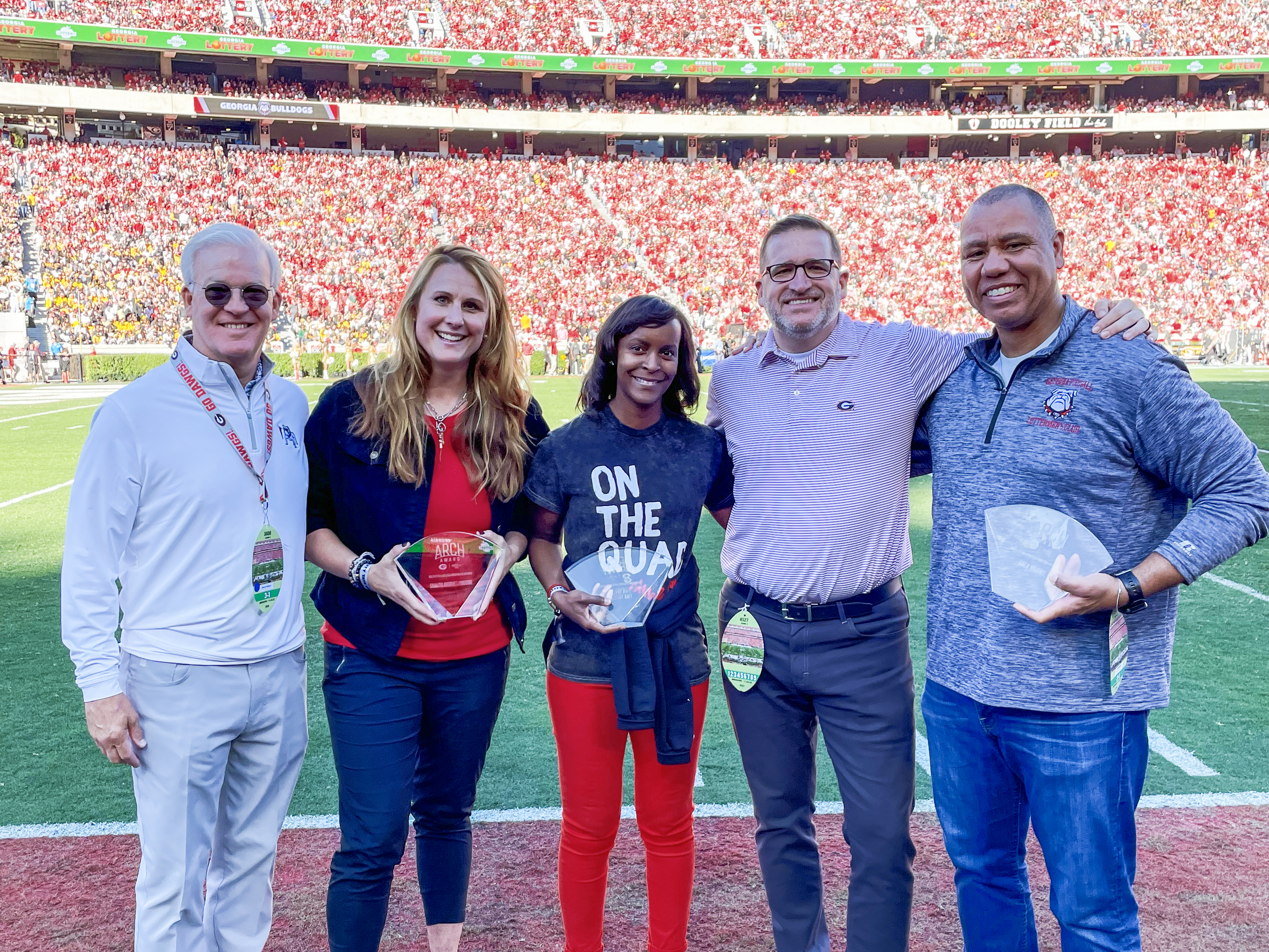 The Piedmont Bank Arch Award 2023 winners receive recognition on Dooley Field during the University of Georgia's Homecoming game Saturday against Missouri. From R-L are Monty Watson, Chairman and CEO, The Piedmont Bank, Samantha Arsenault Livingstone, Tina Taylor, Josh Brooks, J. Reid Parker Director of Athletics, University of Georgia and Greg Bright
