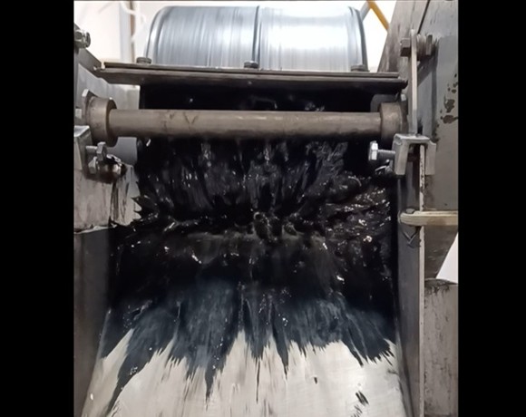Image of Eriez laboratory drum separator collecting magnetic concentrate while operating at a magnetic intensity of approximately 1,000 Gauss, Low Intensity Magnetic Separation (LIMS) process. 