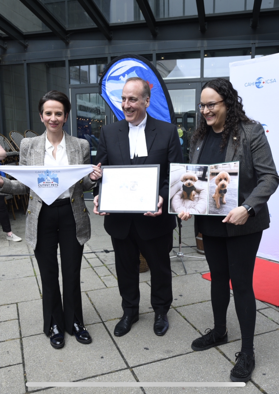 Deputy Speaker Chris d’Entremont presents MP Melissa Lantsman and her wife Lauren Rakowski with a certificate recognizing their dog Winston as the 2024 Cutest Dog runner-up.