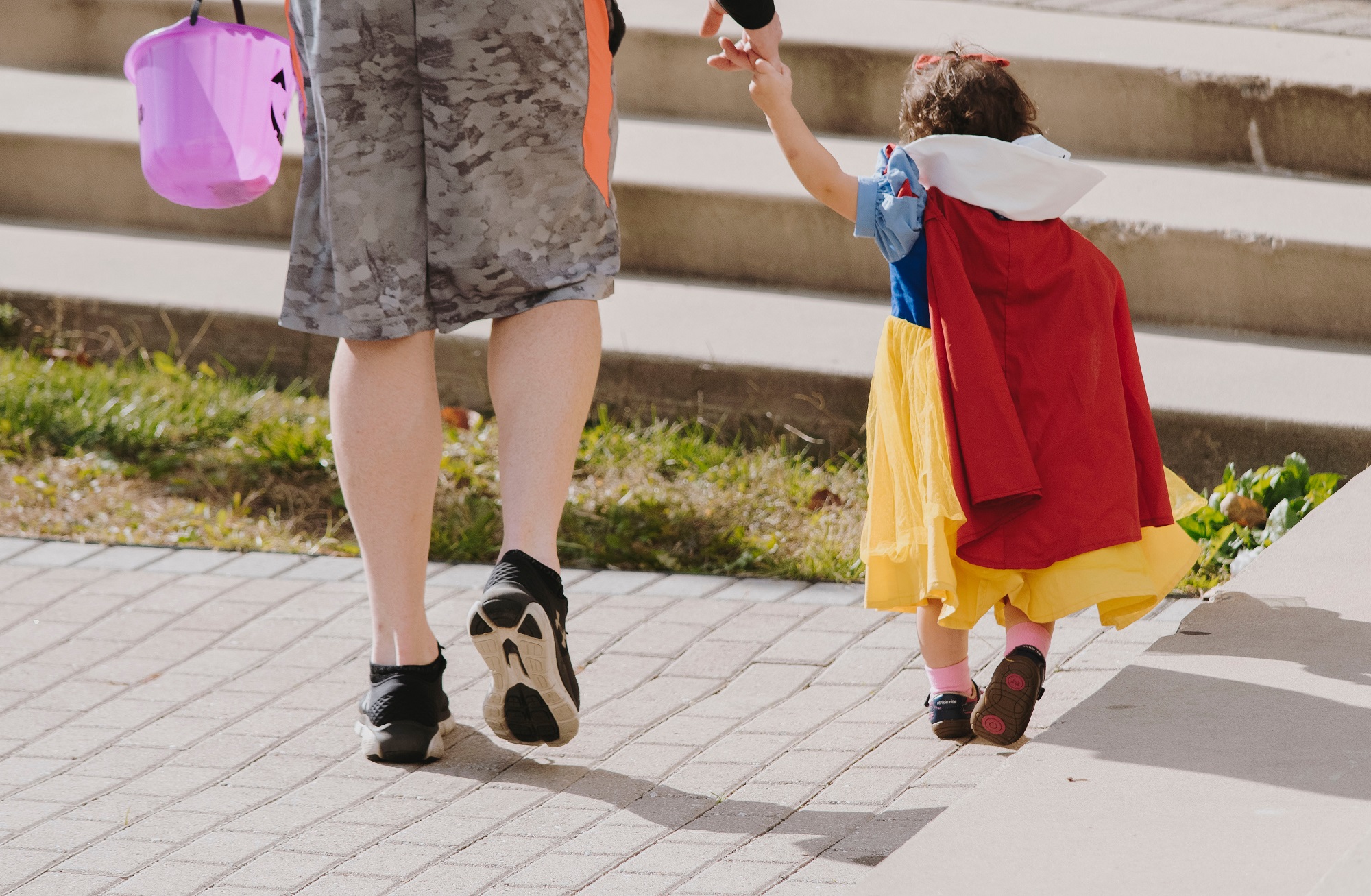 Halloween-Costumed Young Girl and Parent Trick Or Treating