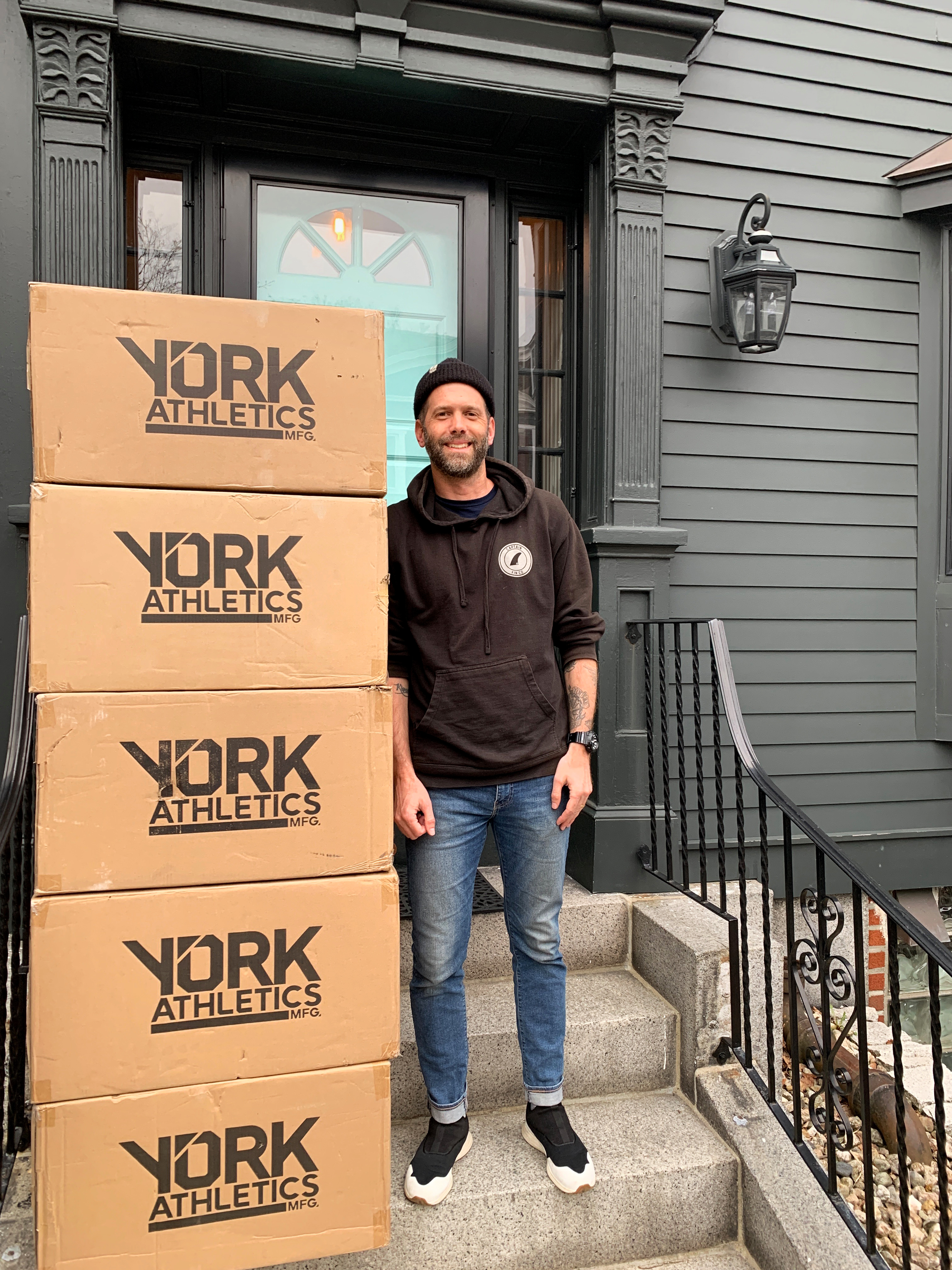 YORK Athletics Co-Founder & CEO Mark McGarry with sneakers donated to Community Servings' COVID-19 frontline workers.