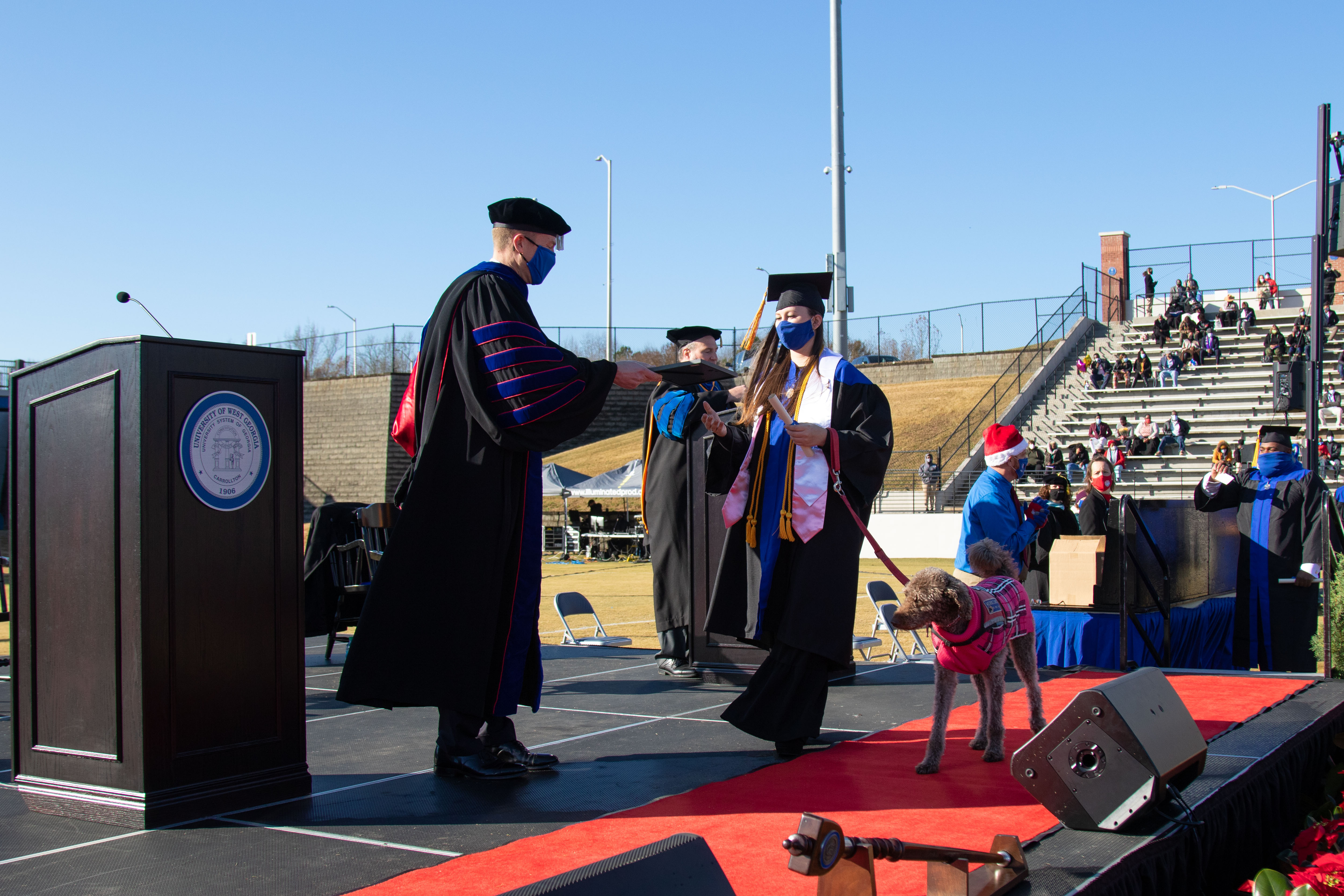 Maggie and Mona Leptrone cross the stage, receiving Mona's honorary "dog-ree" from UWG President Dr. Brendan B. Kelly. Mona was the first canine companion in university history to receive an honorary degree.