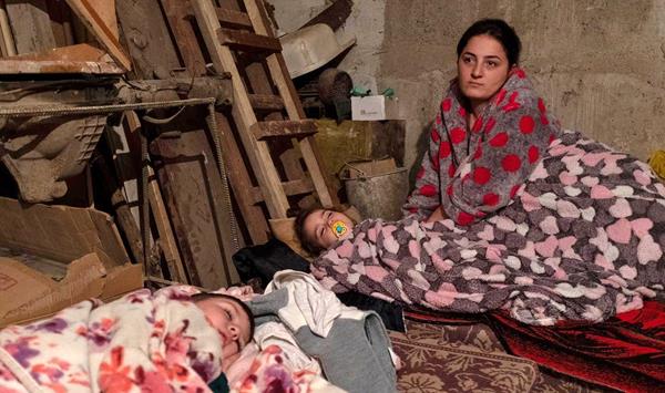 An Armenian woman keeps her children safe in a bomb shelter in Artsakh. Photo: Areg Balayan