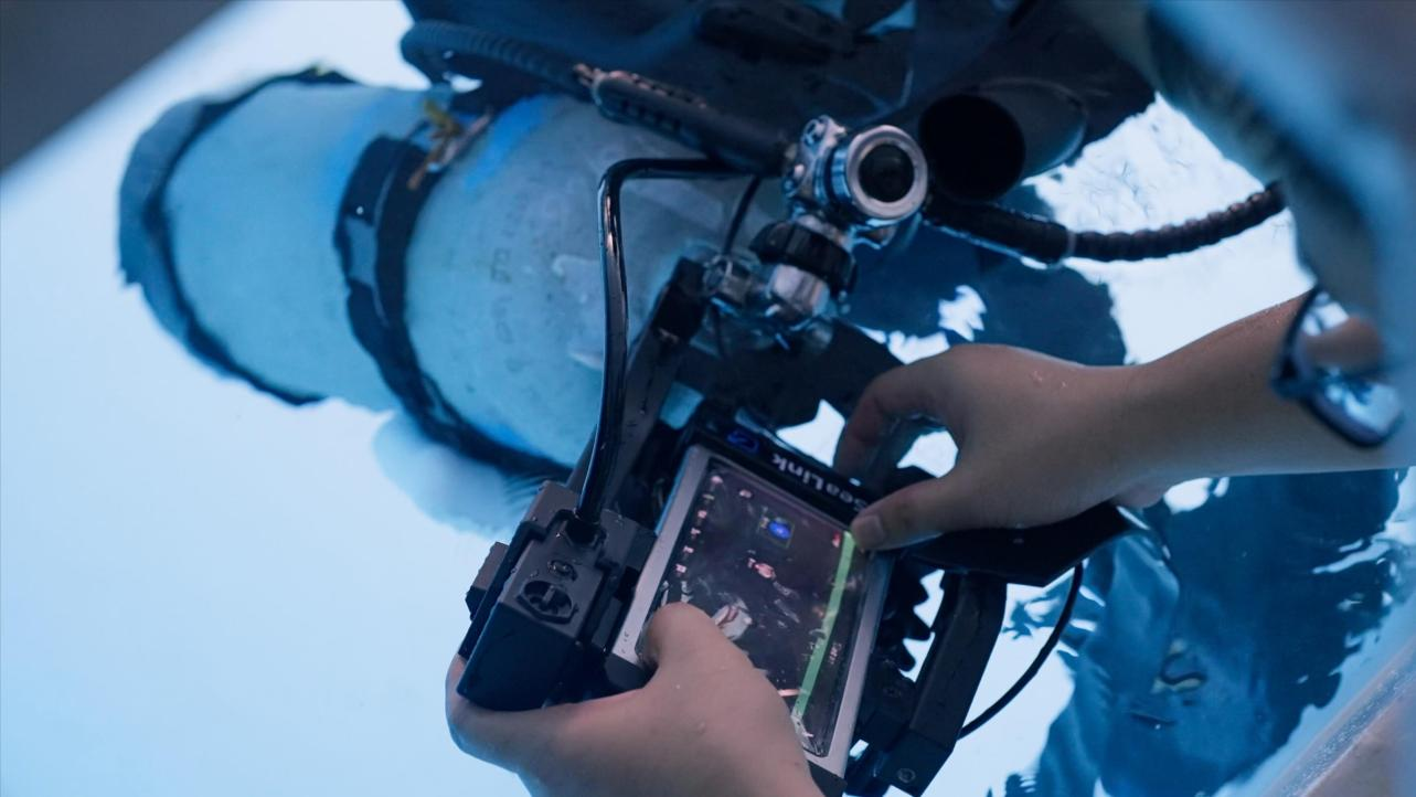 A production monitor shows the underwater performance while the crew adjusts the camera workflow