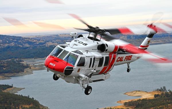 An S-70 FIREHAWK helicopter operated by CAL FIRE can transport firefighters, drop water on wildfires from its 1,000-gallon (3,785 liter) belly tank, and perform hoist rescues. 