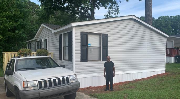 Resident and his home after the Hug-A-Home was completed