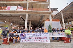 Members of the Ironworkers Local Union 401 take part in a ceremonial beam-signing before the beam was hoisted to the top of the construction site.