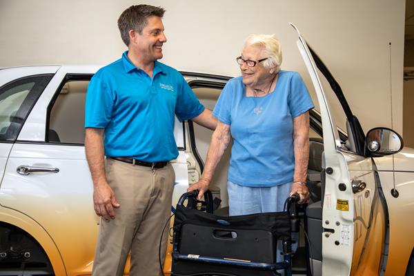 John Mueggenburg, rehabilitation program manager at Eskaton Care Center Fair Oaks, helping a patient during physical therapy by exiting the PT Cruiser.