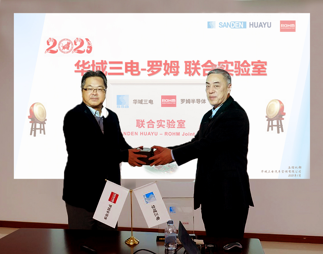 Wang Jun (right), President at Sanden Huayu, and Raita Fujimura (left), Chairman of ROHM Semiconductor (Shanghai) Co., Ltd., exchange gifts at the opening ceremony.