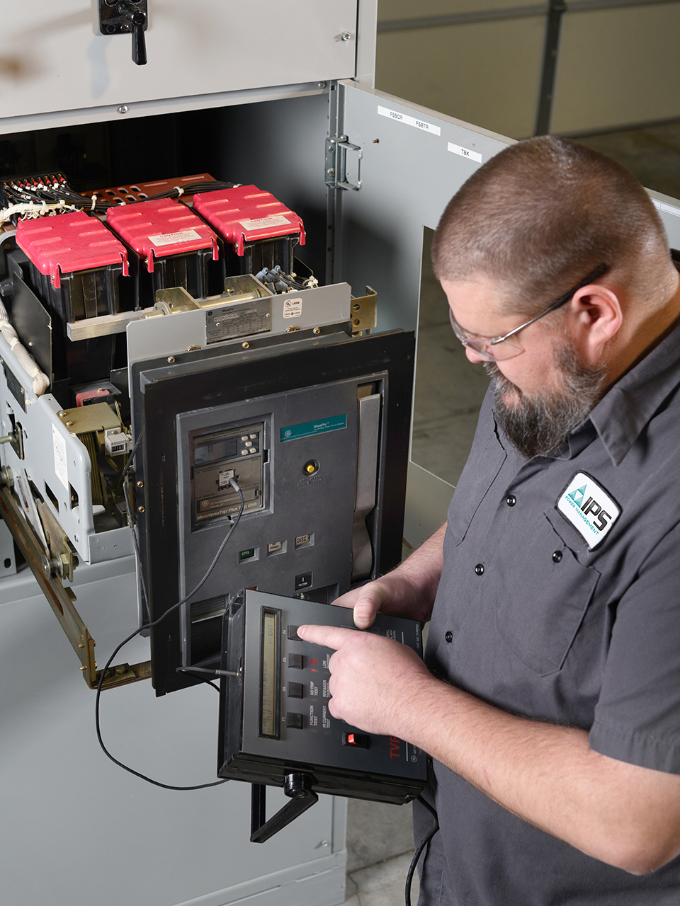 An IPS technician conducts secondary testing on an insulated case breaker.